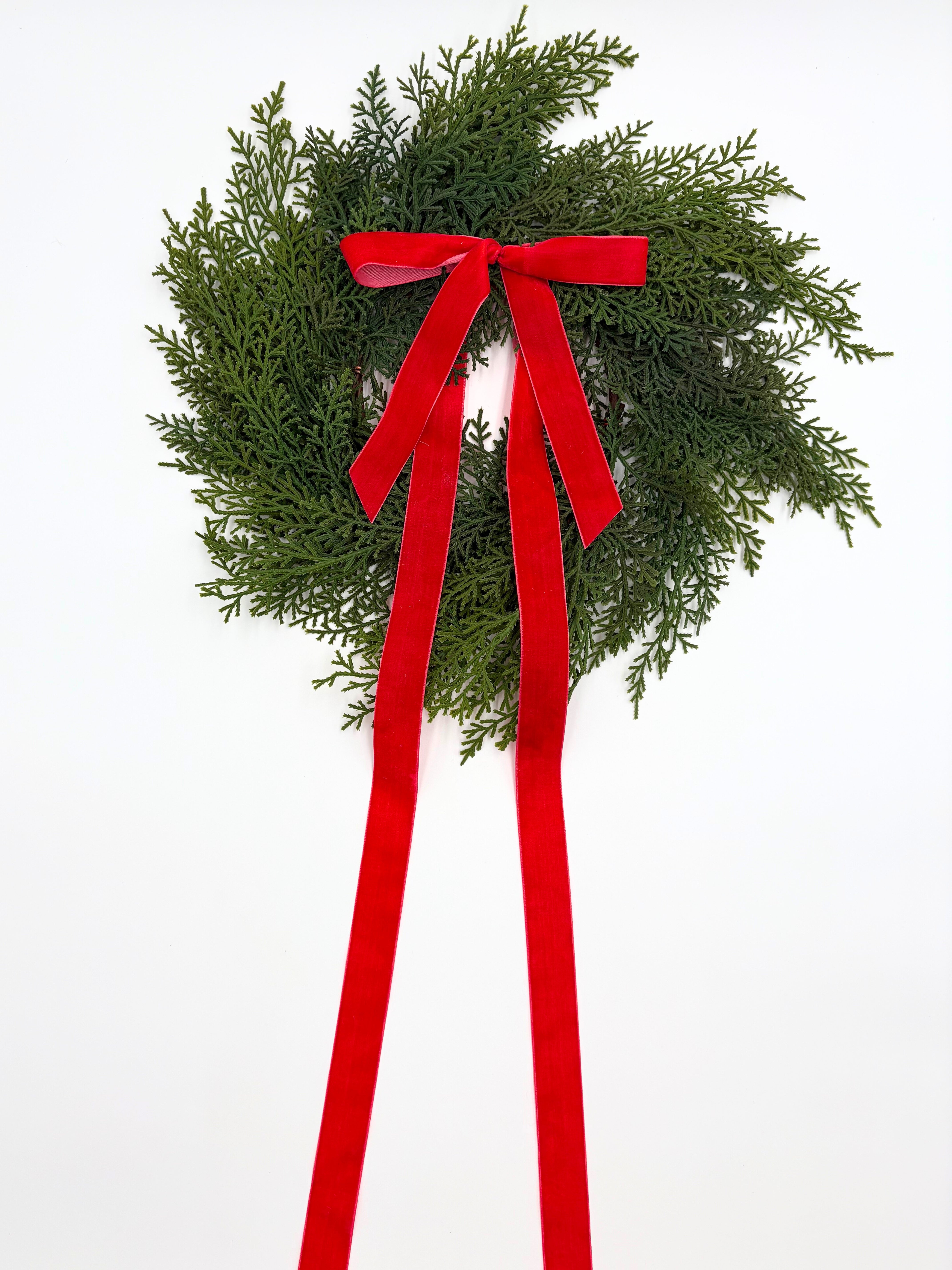 Mini Christmas cedar wreath with long red velvet ribbon for farmhouse cabinet or holiday home decor.