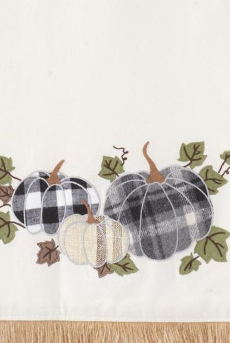 72-inch cream canvas table runner with plaid pumpkin appliqué and rustic jute fringe.