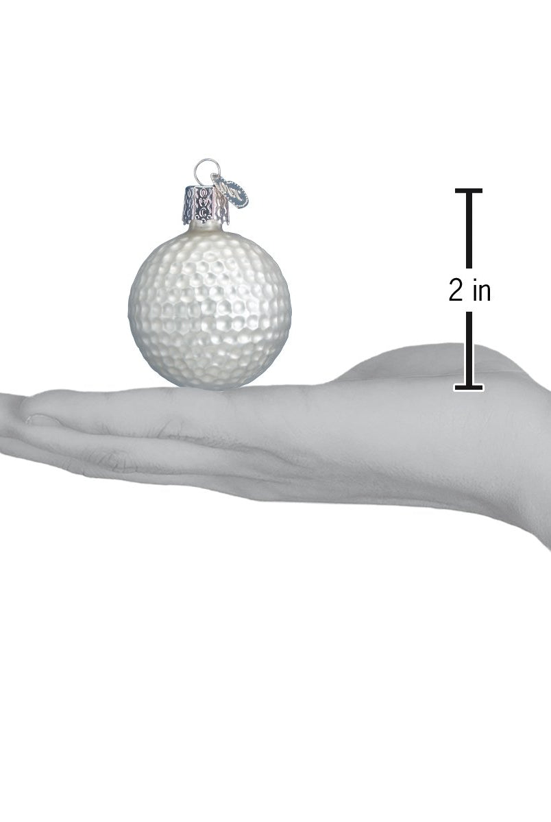 White glass golf ball Christmas ornament held in a hand, measuring 2 inches in height with a silver hanging cap.