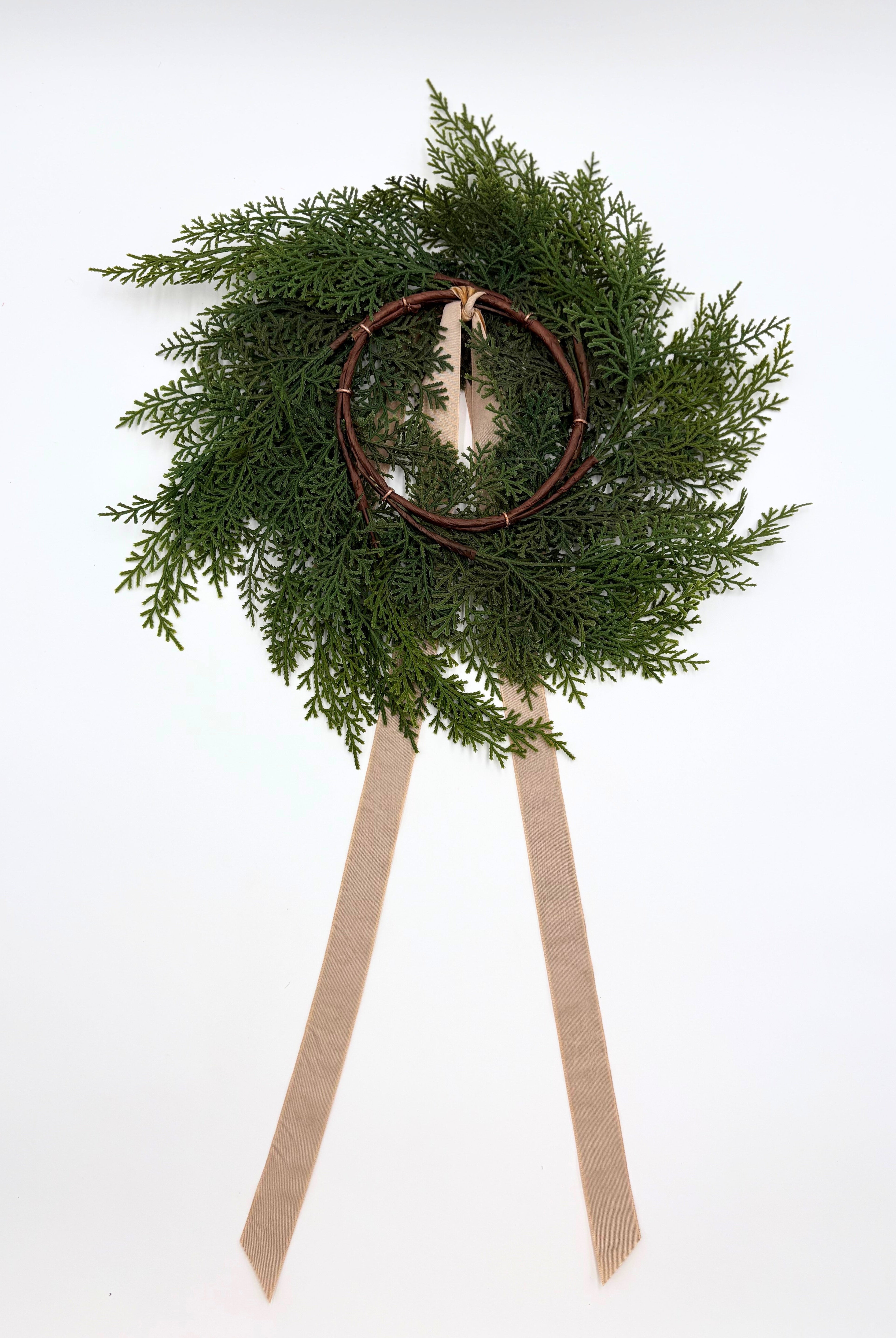 Mini faux cedar cabinet wreath with a rustic twig base and elegant caramel velvet ribbon on a white background.