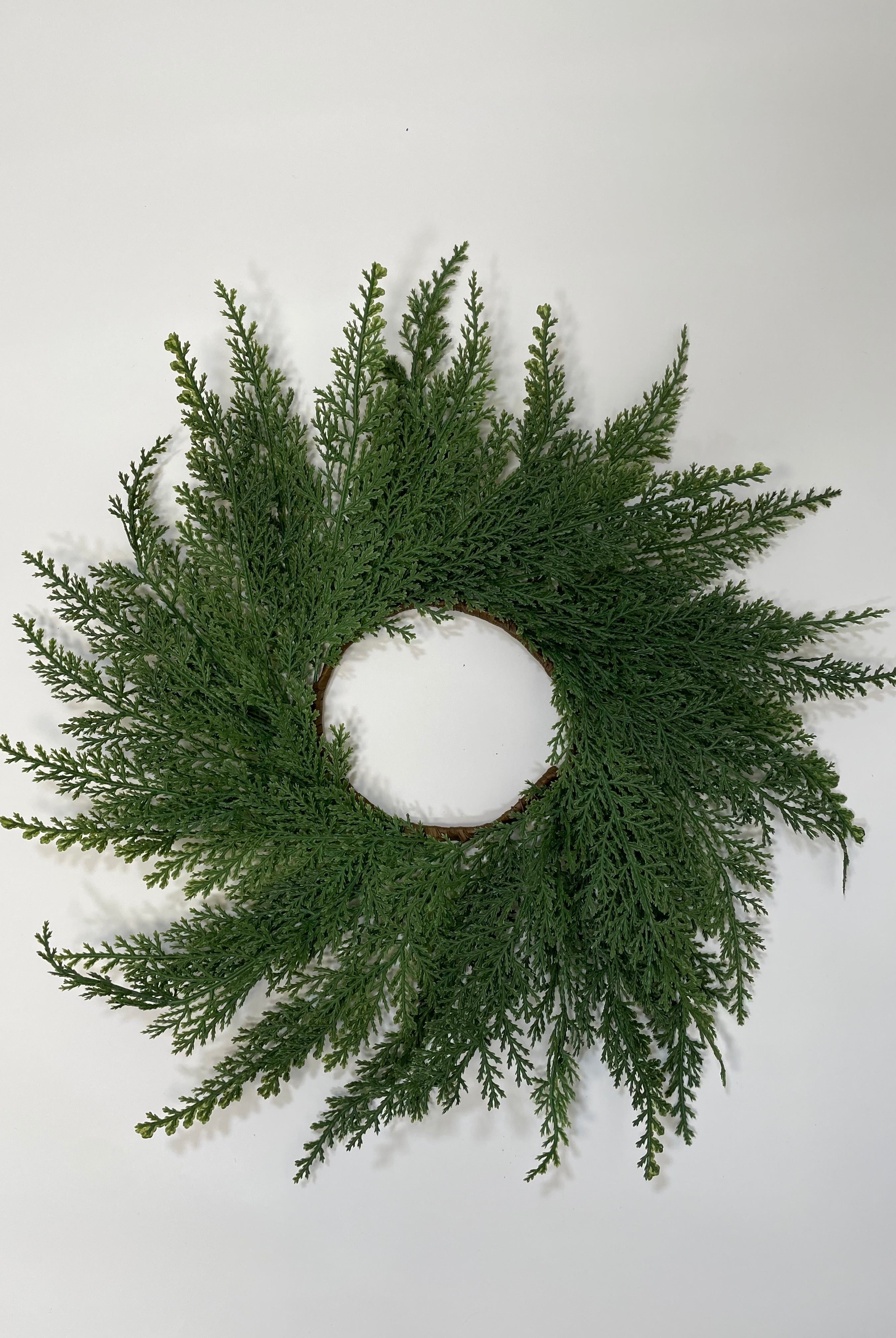14-inch mini Christmas wreath made of realistic green faux cedar branches on a simple circular frame.