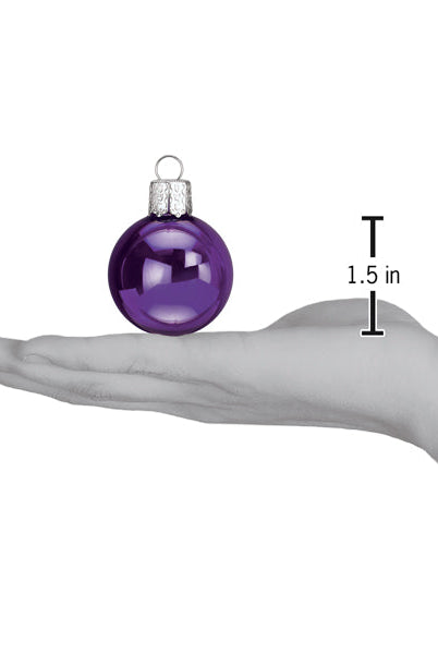 Shiny purple 1.5-inch Halloween ornament ball held in a hand to show scale.