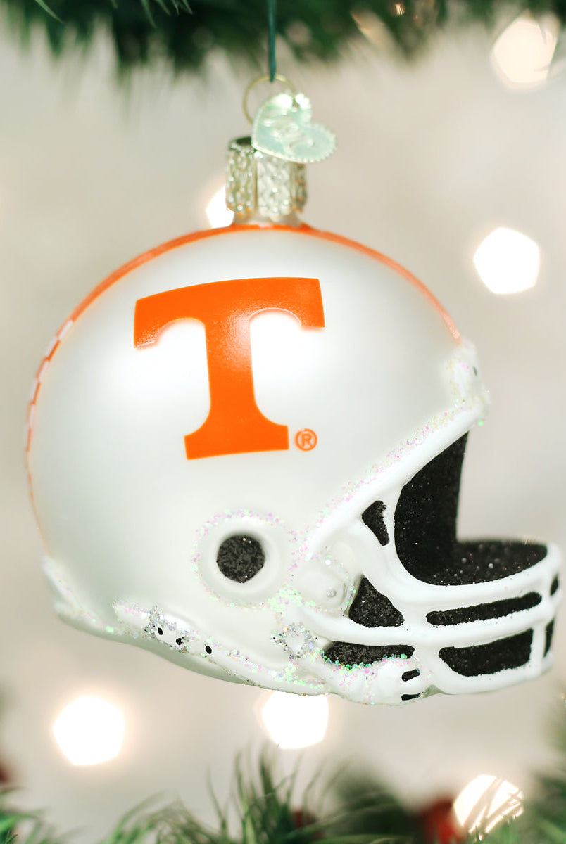 White Tennessee Volunteers glass football helmet ornament with an orange T logo and glittery accents hanging on a tree.