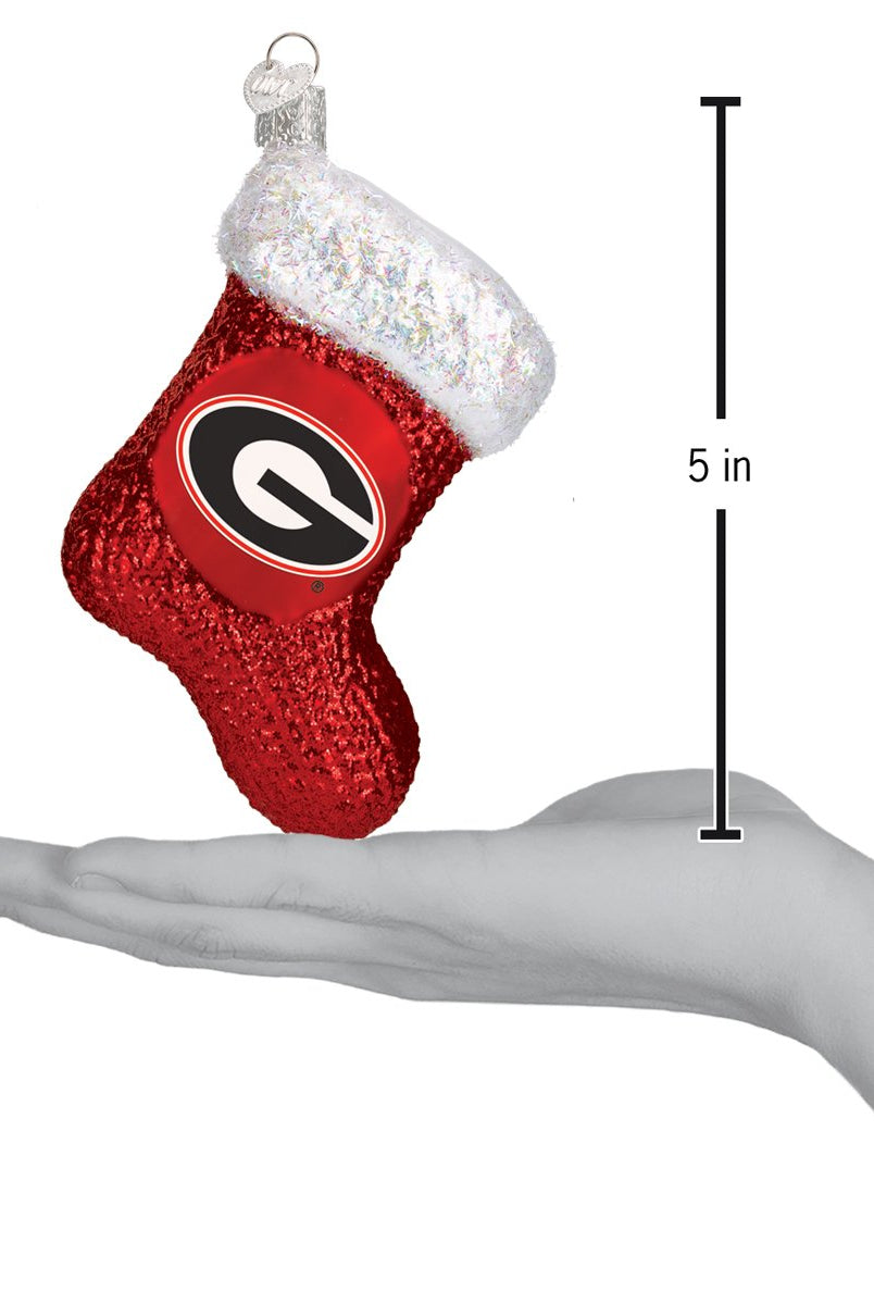 5-inch red glittery Georgia Bulldogs stocking ornament with a white iridescent cuff held in a hand.