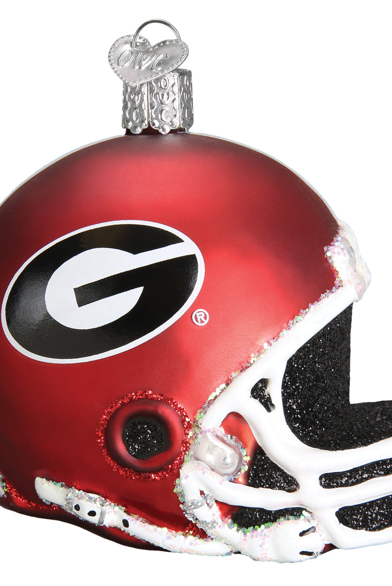 Red glass Georgia Bulldogs football helmet ornament with a black G logo, white facemask, and glitter accents.