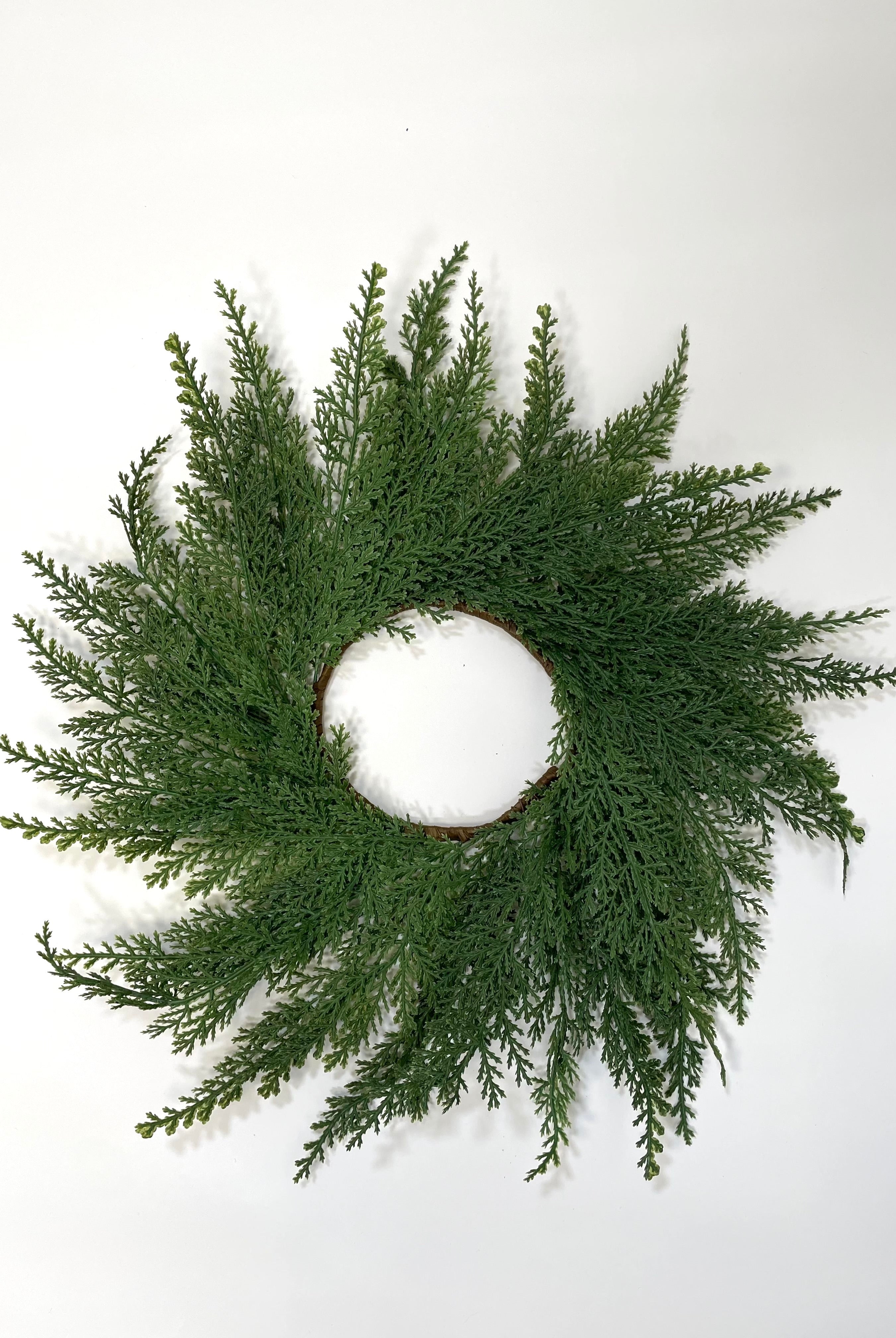 14-inch farmhouse mini Christmas wreath made of realistic green faux cedar branches on a simple round frame.