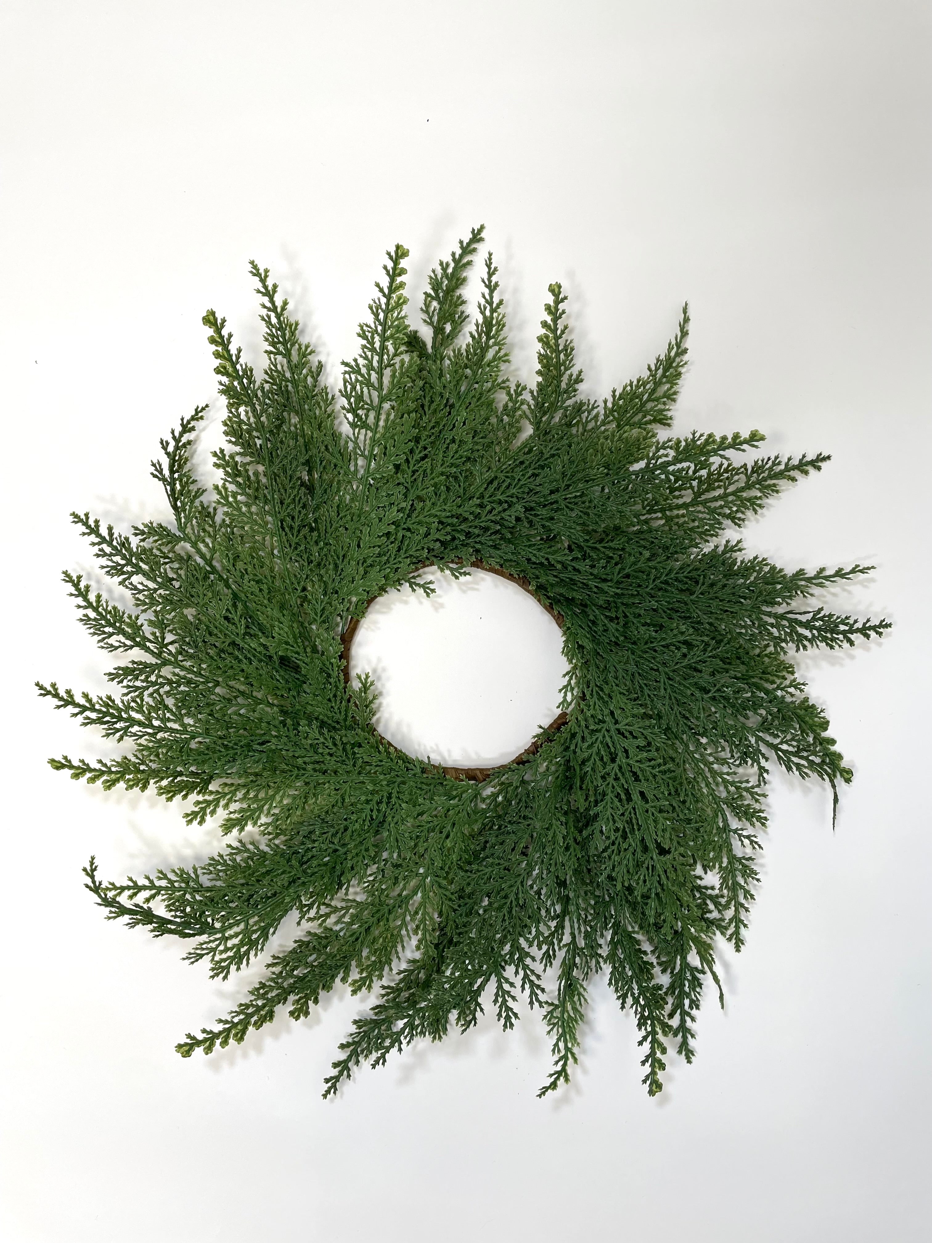 14-inch farmhouse mini Christmas wreath made of realistic green faux cedar branches on a simple round frame.