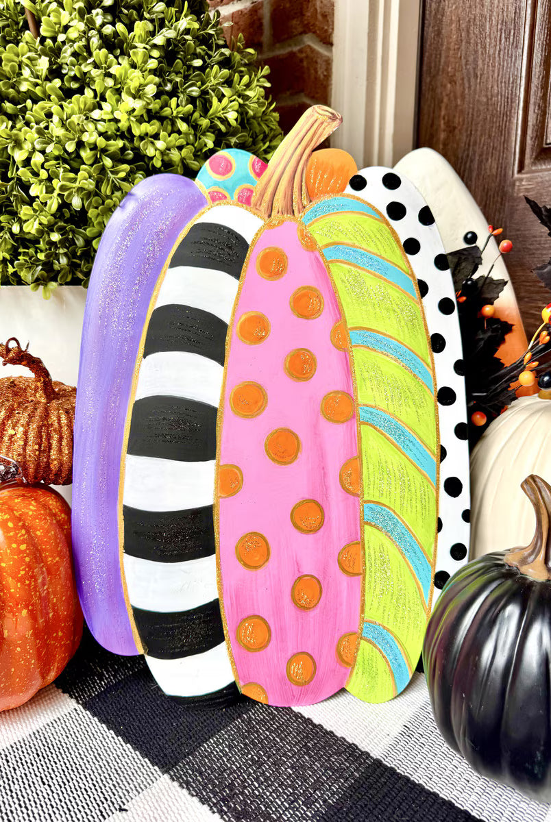 Tall, colorful pumpkin stake featuring vibrant stripes, polka dots, and glittery accents for festive fall garden decor.