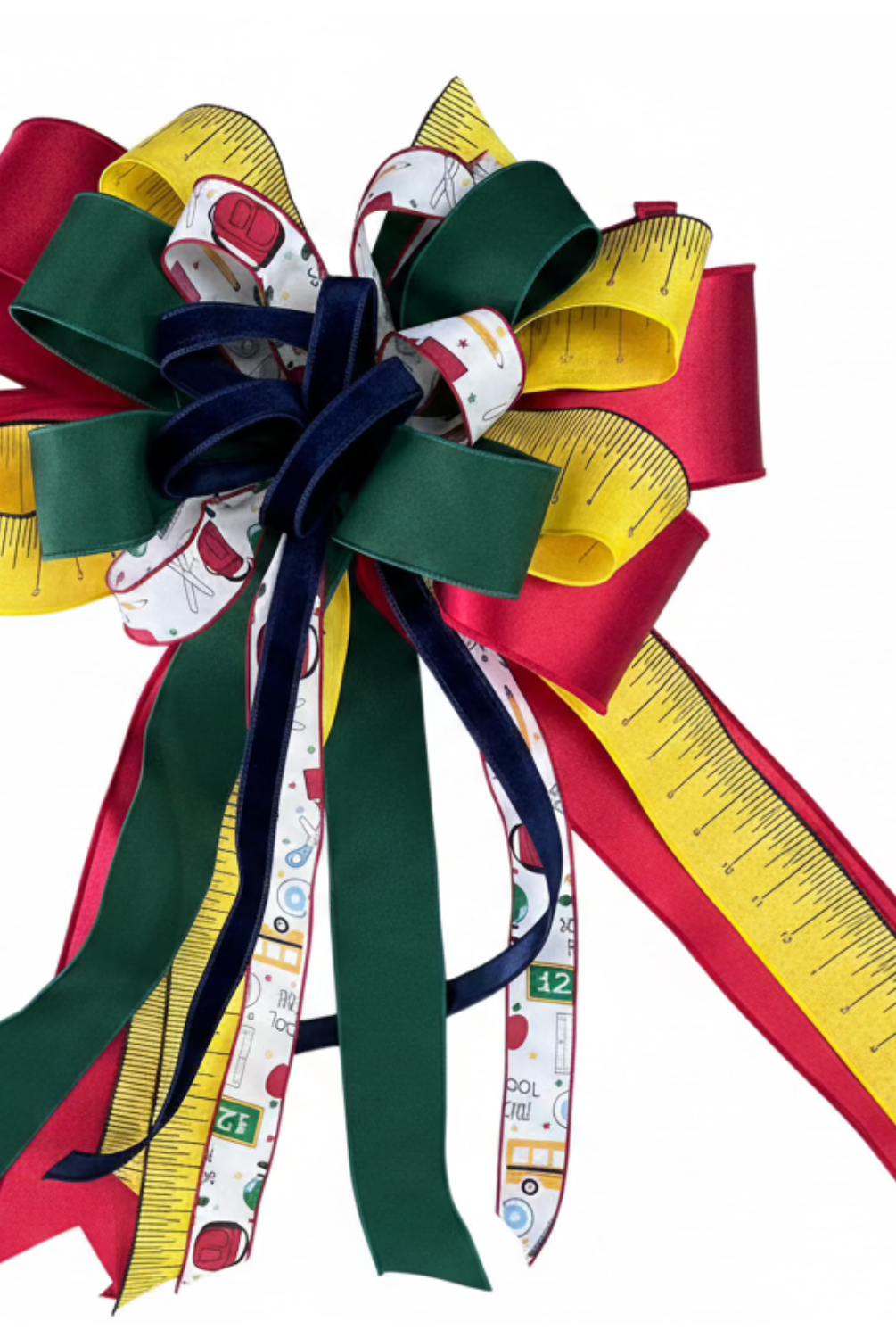 Large back-to-school decorative bow with red, green, and yellow ruler-patterned ribbons and school supply motifs.