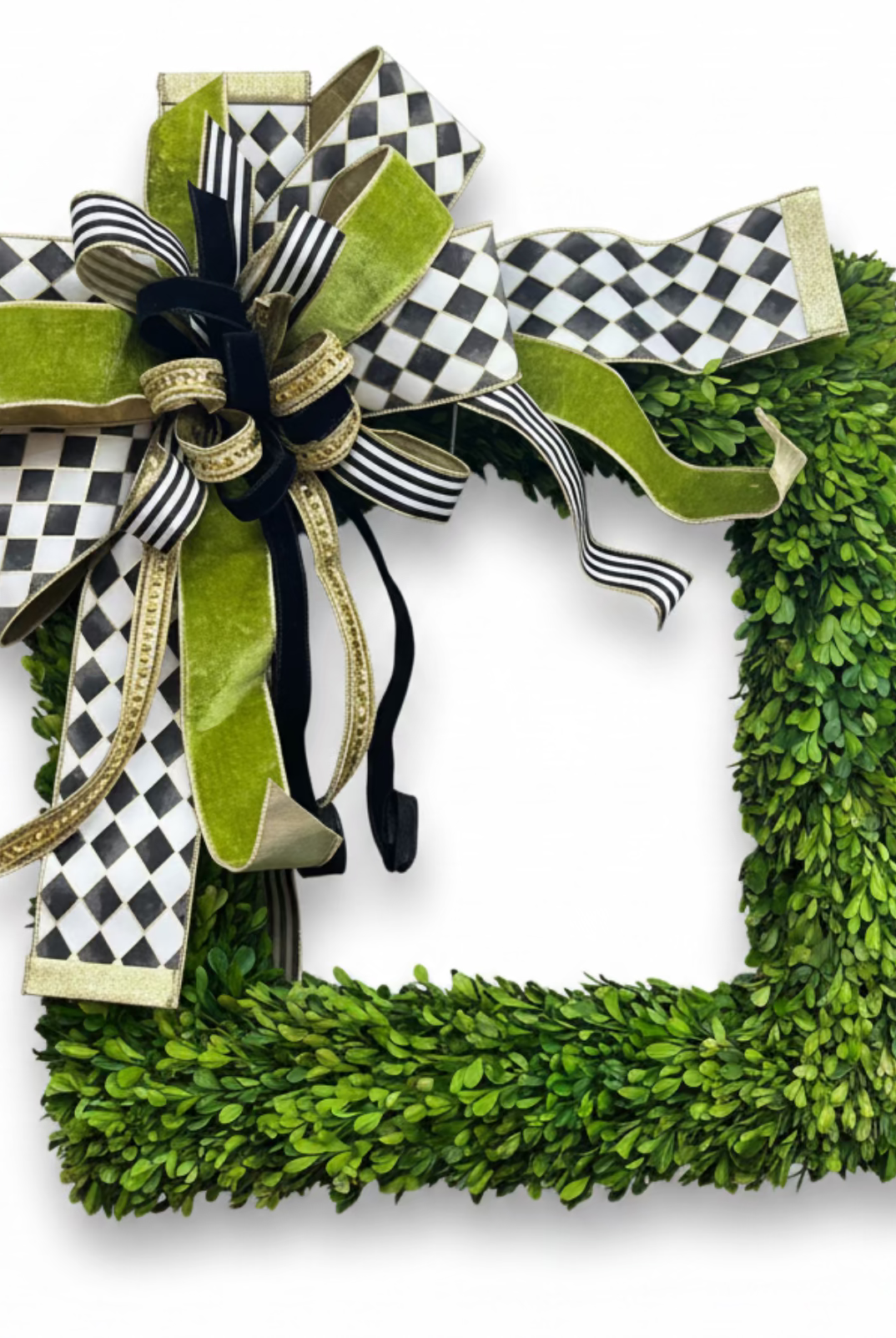Large designer bow in black, white, and gold featuring checkered and velvet ribbons attached to a square boxwood wreath.