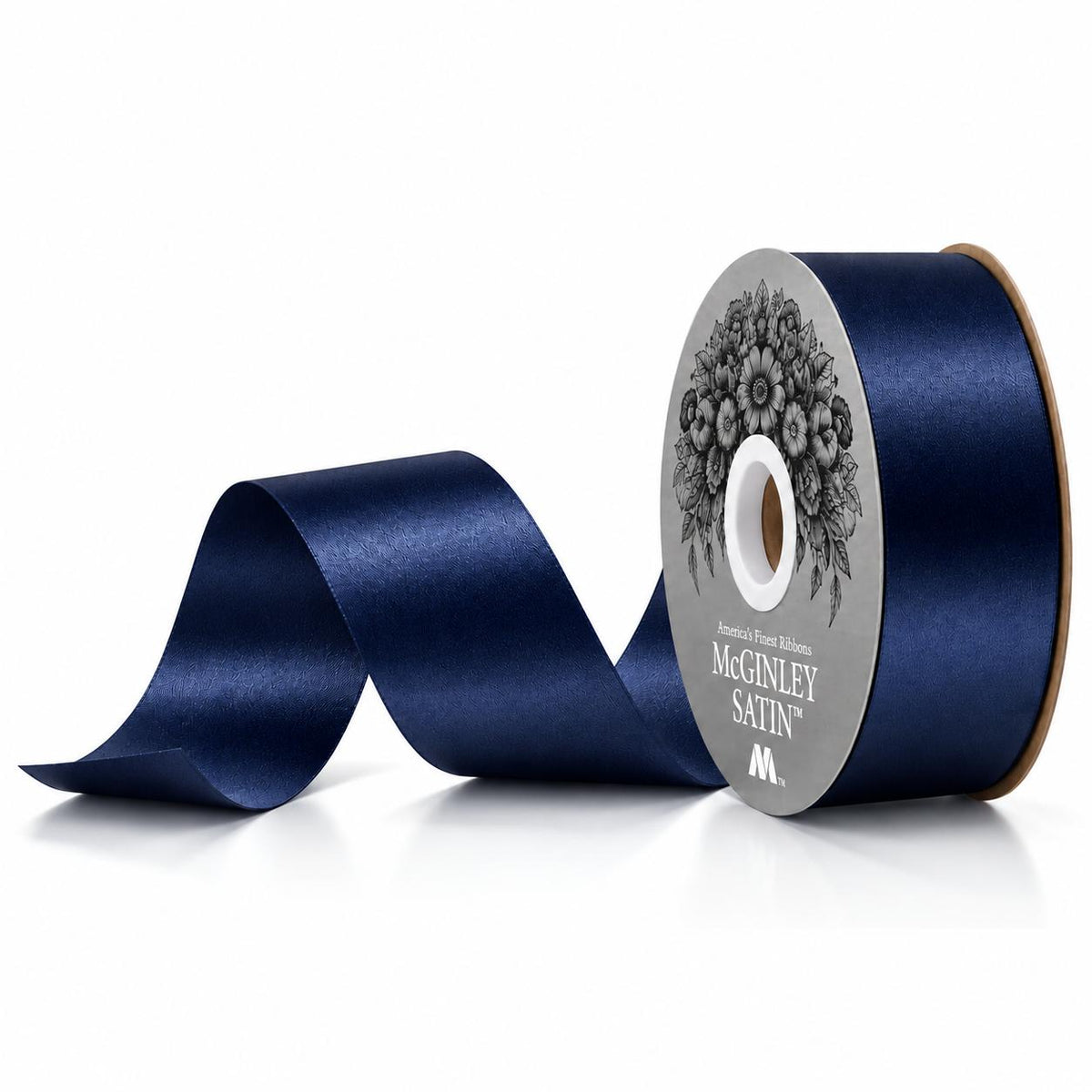 Navy blue satin acetate homecoming ribbon unspooling from cardboard core