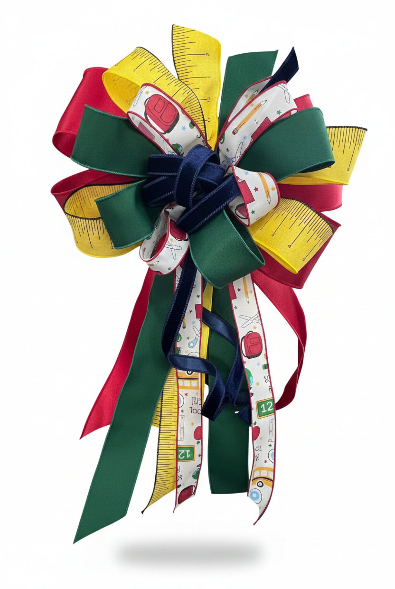 Large back-to-school bow featuring red, green, and yellow ribbons with school supply patterns and ruler prints.
