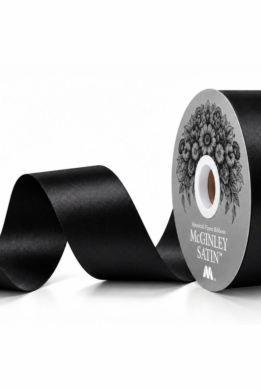 Unrolling black satin acetate ribbon showing smooth lustrous finish