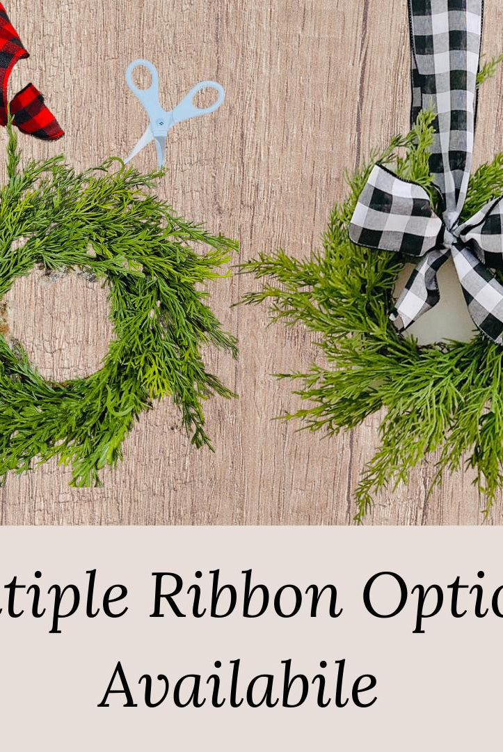 Mini artificial cedar Christmas wreaths featuring red or black and white buffalo check ribbon bows.