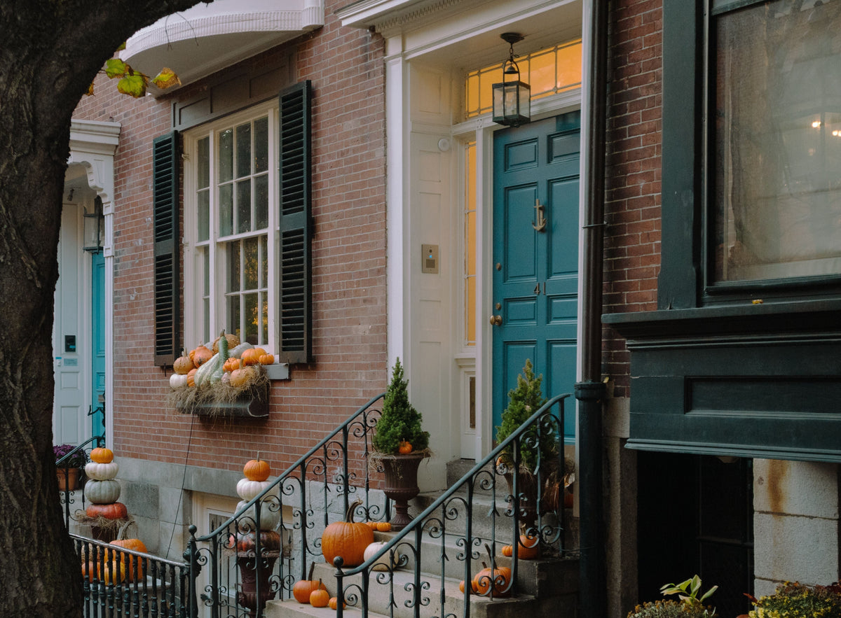 Brick townhouse entrance decorated with Halloween pumpkins. 