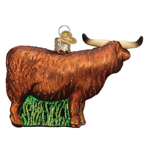 Brown glass Highland cow Christmas ornament with glittery fur texture, long horns, and a green base on a white background.
