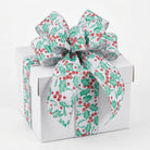 White wired edge ribbon with holly berry pattern tied on gift box