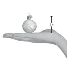 White glass golf ball Christmas ornament held in a hand, measuring 2 inches in height with a silver hanging cap.