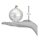 Mouth-blown white glass volleyball ornament with silver glitter accents, measuring 3.25 inches, held in a hand.