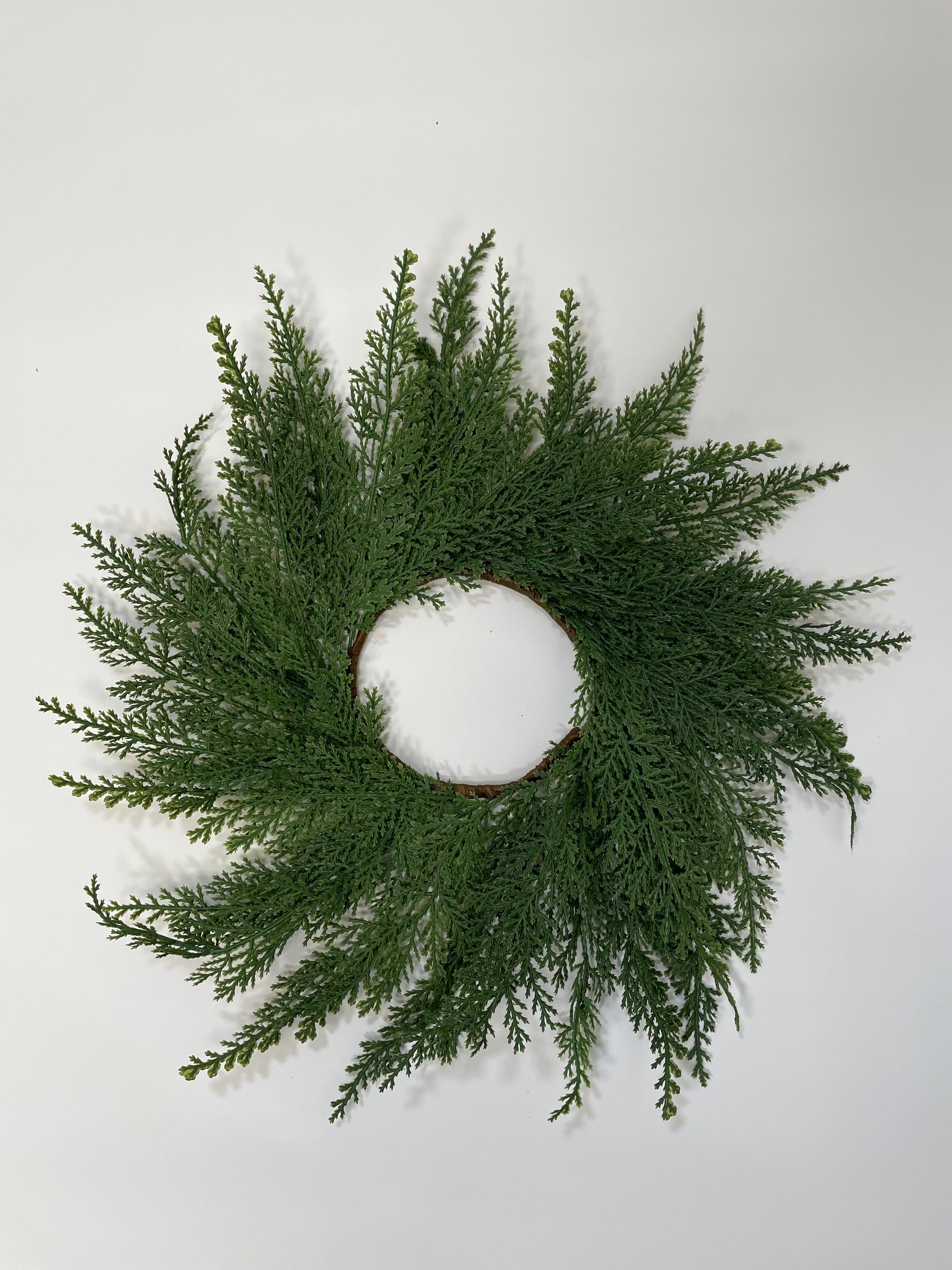 14-inch mini Christmas wreath made of realistic green faux cedar branches on a simple circular frame.