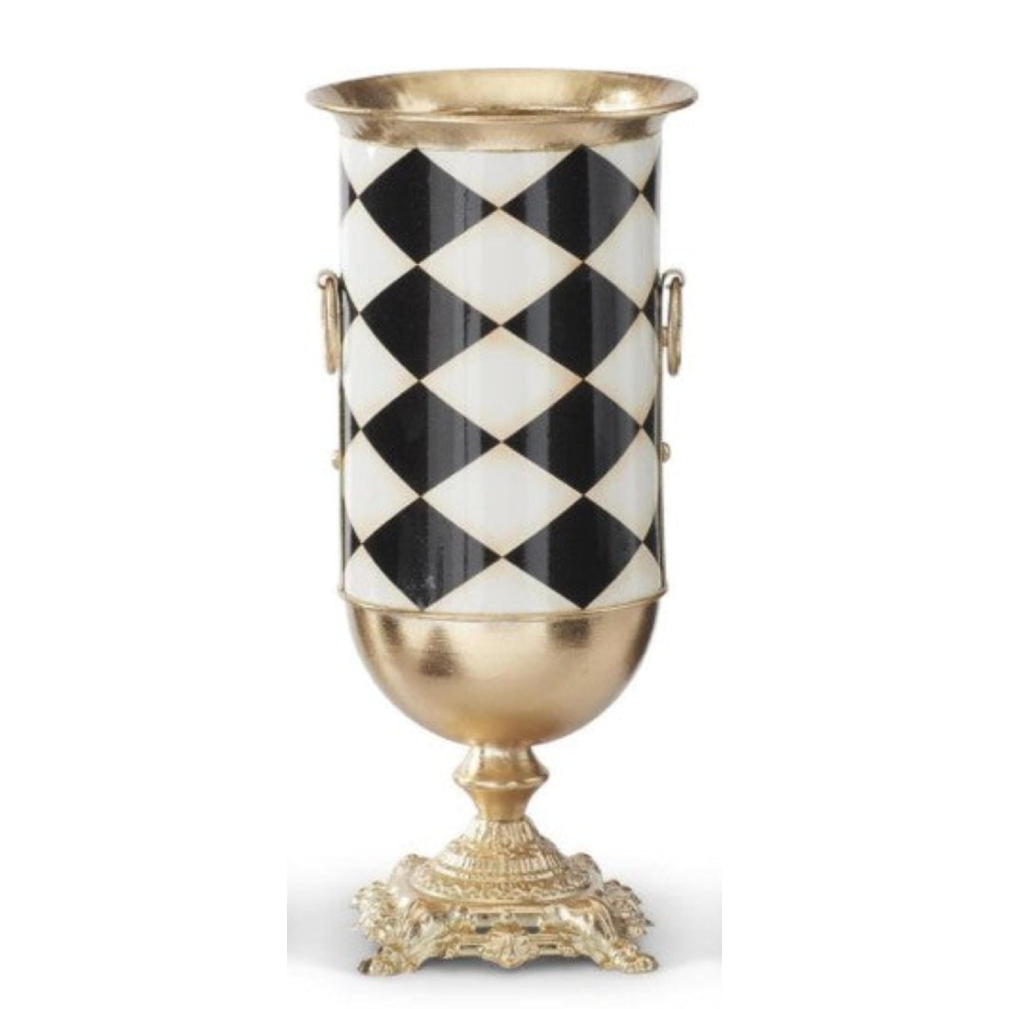 Black and white harlequin check urn vase with gold base, rim, and side handles on a decorative pedestal stand.