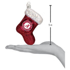 5-inch red glittery Alabama Crimson Tide stocking ornament with a white iridescent cuff held in a hand.