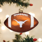 Burnt orange glass football ornament featuring the white Texas Longhorns logo and glittery white stripes.