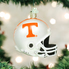 White Tennessee Volunteers glass football helmet ornament with an orange T logo and glittery accents hanging on a tree.