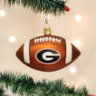 Glass Georgia Bulldogs football ornament with a brown textured finish, white glitter laces, and the team G logo.