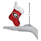 5-inch red glittery Georgia Bulldogs stocking ornament with a white iridescent cuff held in a hand.
