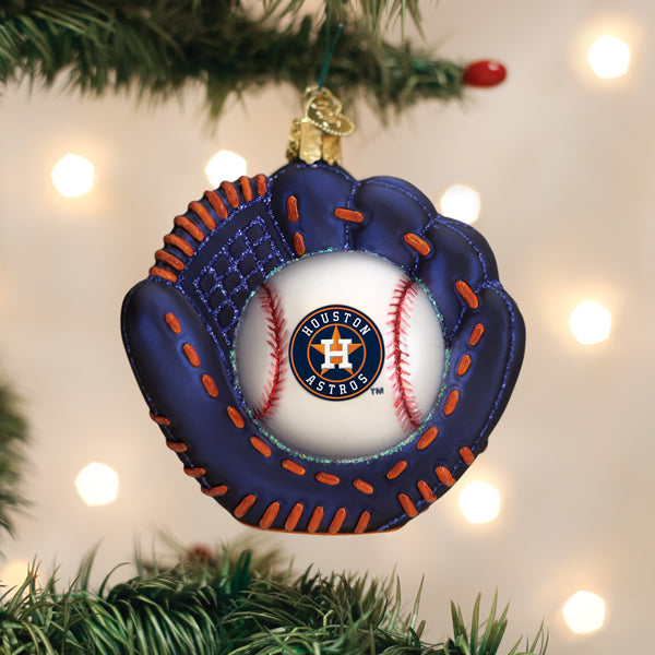 Navy blue baseball mitt ornament with orange stitching and a Houston Astros logo baseball center, hanging on a tree.