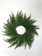 14-inch farmhouse mini Christmas wreath made of realistic green faux cedar branches on a simple round frame.