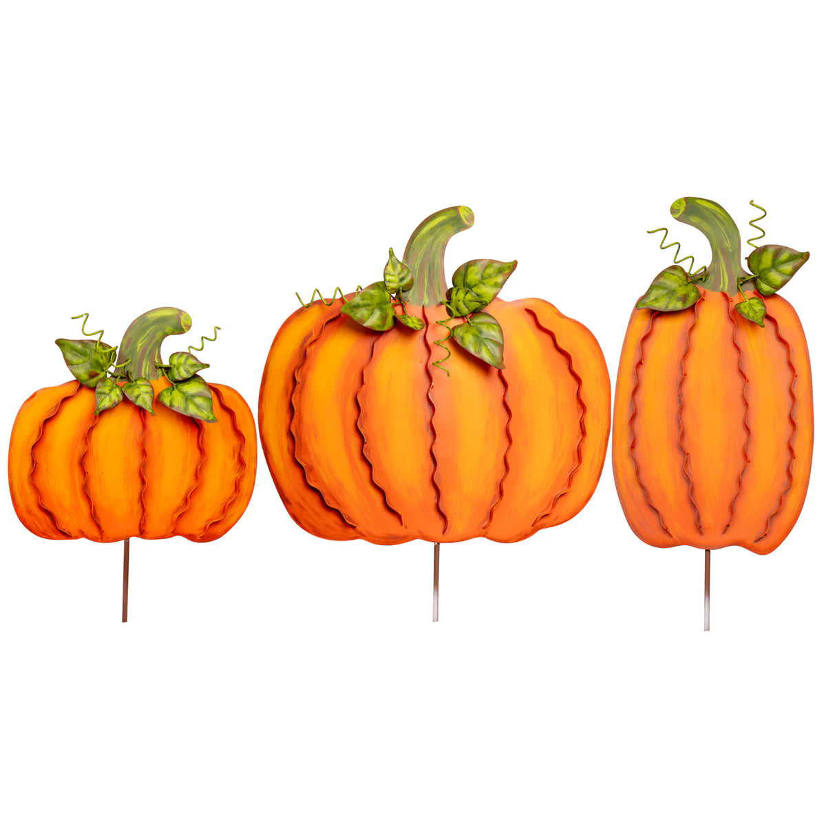 Set of three orange metal pumpkins with decorative ribbon edges, green leaves, and stakes for fall garden or home decor.