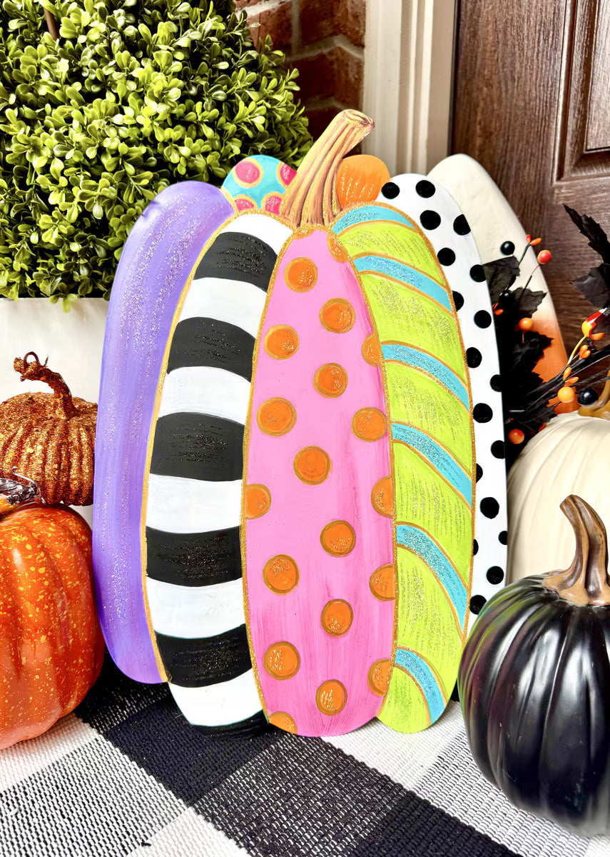 Tall, colorful pumpkin stake featuring vibrant stripes, polka dots, and glittery accents for festive fall garden decor.