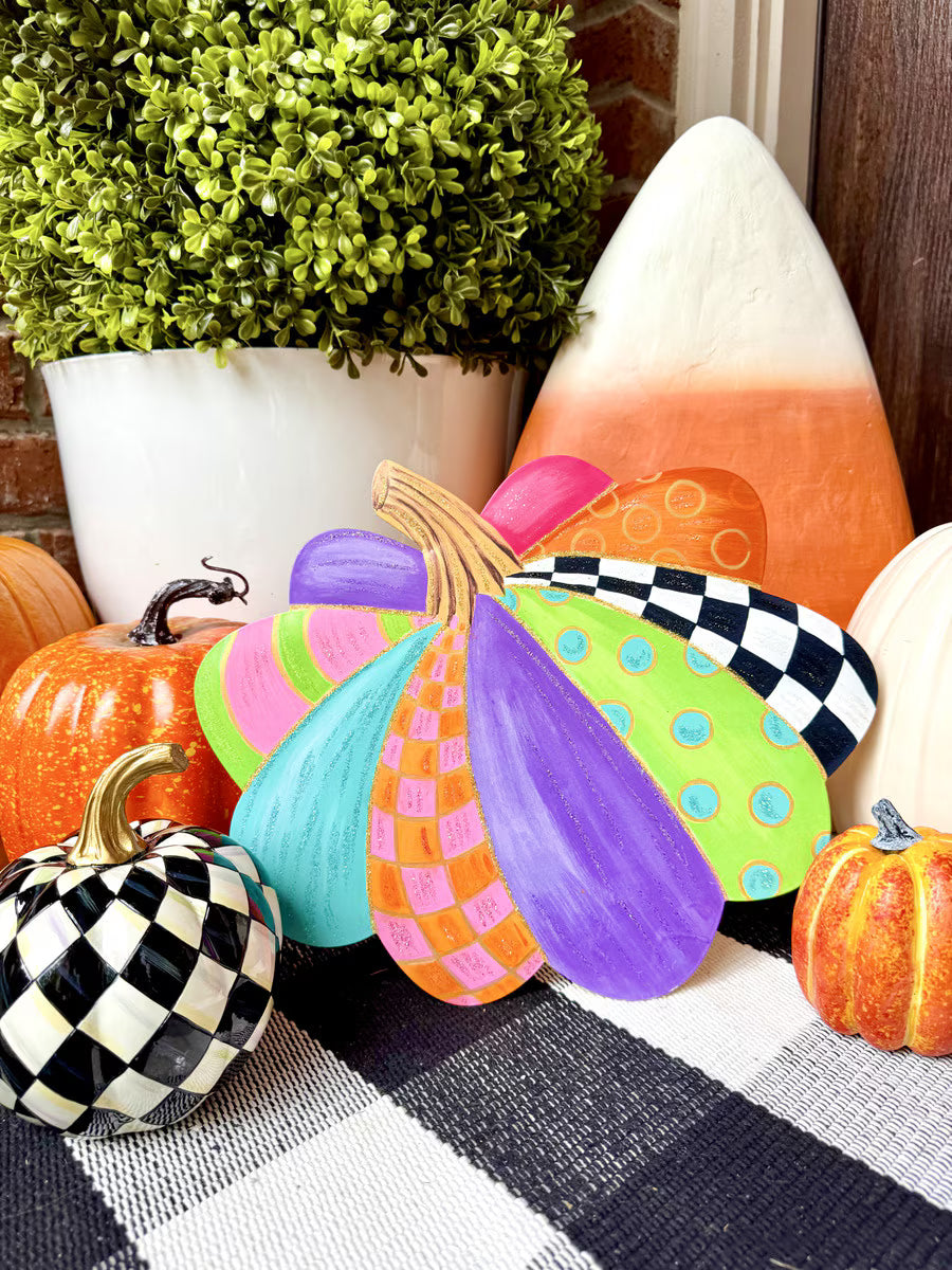 Small decorative pumpkin stake featuring colorful, patterned sections in bright purple, teal, lime green, and orange.