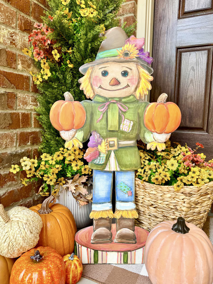 35.5-inch tall wooden scarecrow nutcracker holding two pumpkins, featuring rustic autumn colors and floral accents.