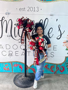 Large red and black football-themed decorative bow with glitter accents and long ribbon tails for sports decor.