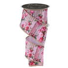 Wired edge ribbon spool featuring pink roses on distressed wood