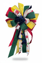 Large back-to-school bow featuring red, green, and yellow ribbons with school supply patterns and ruler prints.