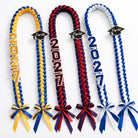 Set of three braided graduation leis in gold, maroon, and white with cap charms
