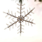 Large 9-inch clear acrylic beaded snowflake ornament with sparkling crystal-like facets hanging from a tree branch.