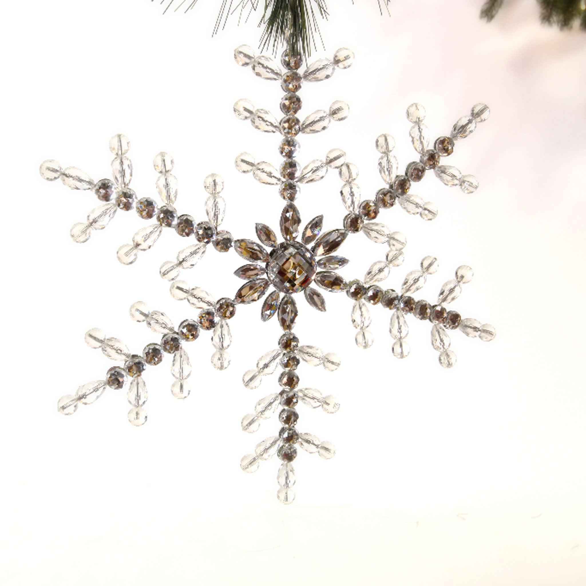 Large 9-inch clear acrylic beaded snowflake ornament with sparkling crystal-like facets hanging from a tree branch.