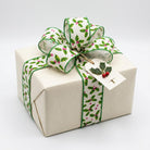 Red and green holly wired edge ribbon bow on cream gift box