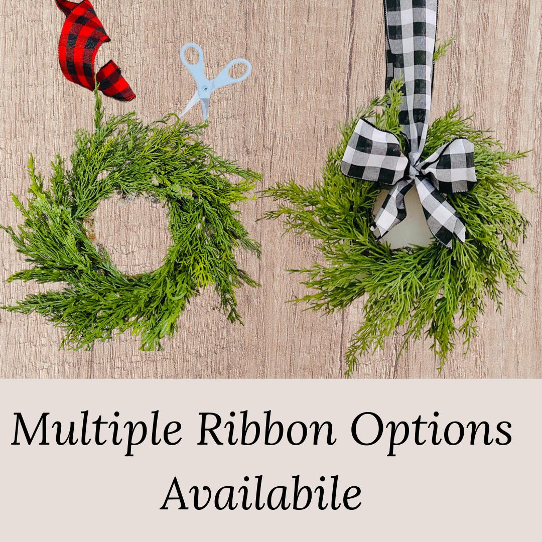 Mini artificial cedar Christmas wreaths featuring red or black and white buffalo check ribbon bows.