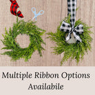 Mini artificial cedar Christmas wreaths featuring red or black and white buffalo check ribbon bows.